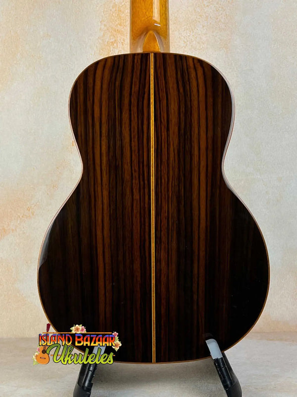 Acoustic guitar with dark striped wood grain back, highlighting Ohana TK-50G Rosewood Tenor Ukulele