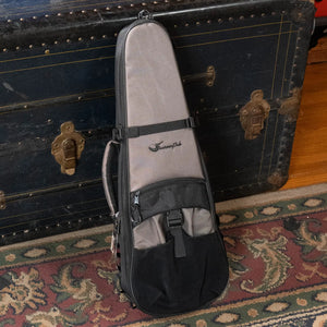 Gray and black fender ukulele case with a mesh panel, adjustable strap, and front pocket.