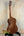 Wooden Kala Archtop Tenor Ukulele KA-JTE-BKGN on a black stand showcasing classic design