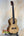 Natural wood Acacia Tenor Ukulele on a black stand, perfect for Island Bazaar Ukes