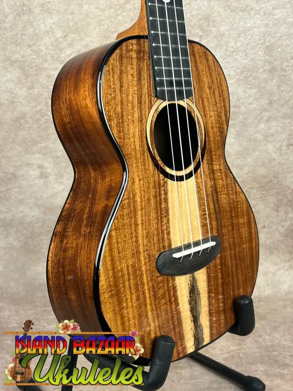 Glossy brown Kala Contour Series Tenor Ukulele with solid acacia body and white strings