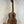 Wooden ukulele on stand, showcasing Kala KA-8 Eight-String Tenor in gloss mahogany finish