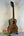 Wooden ukulele on stand, showcasing Kala KA-8 Eight-String Tenor in gloss mahogany finish