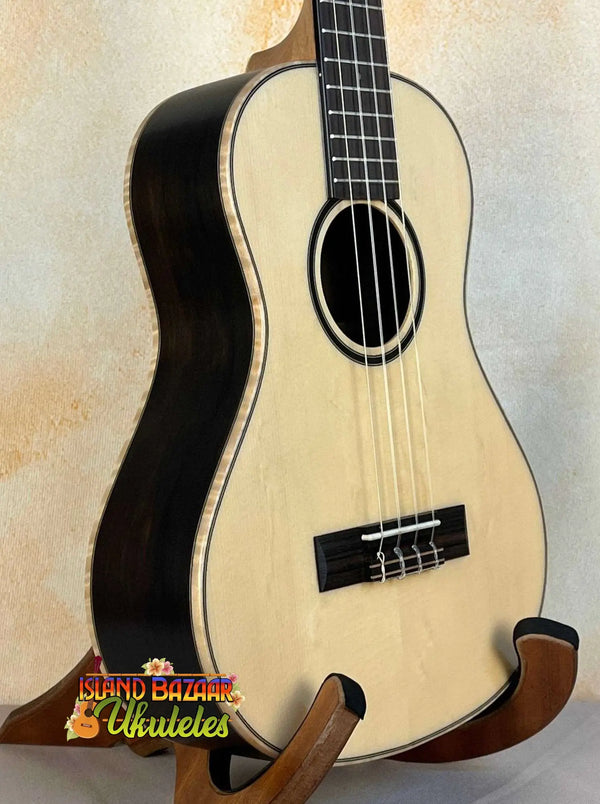 Natural wood Kala KA-ASZCT-ST Super Tenor Ukulele with black binding on a stand