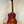 Sunburst-colored acoustic guitar on black stand, featuring Kala KA-FMCB-T gloss flame maple Cherry Burst