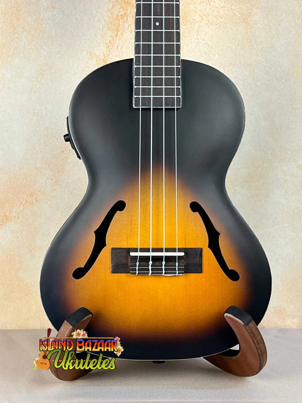 Sunburst-colored Archtop Tenor Ukulele on a stand, Kala KA-JTE-2TS with f-holes