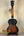 Sunburst-colored Kala KA-JTE-2TS Archtop Tenor Ukulele on a wooden stand