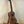 Wooden Kala KA-SA-C Acacia Concert Ukulele with four strings on a black stand