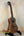 Wooden Kala KA-SA-C Acacia Concert Ukulele with four strings on a black stand