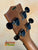 Guitar headstock with black tuning pegs on Kala KA-SA-C Acacia Concert Ukulele