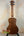 Wooden Kala KA-SA-C Acacia Concert Ukulele on a sleek black stand