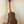 Wooden Kala KA-SA-C Acacia Concert Ukulele resting on a sleek black stand