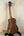 Wooden Kala KA-SA-C Acacia Concert Ukulele resting on a sleek black stand