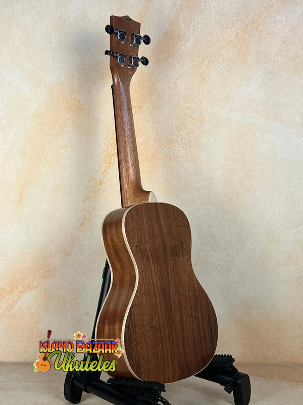 Wooden Kala KA-SA-C Acacia Concert Ukulele resting on a sleek black stand