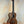 Wooden Kala KA-SA-T Acacia Tenor Ukulele with dark grain on a black stand