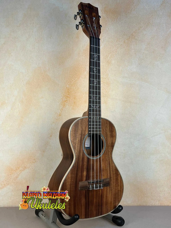 Wooden Kala KA-SA-T Acacia Tenor Ukulele with dark grain on a black stand