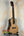 Natural wood Kala KA-SCAC-C Concert Ukulele on black stand showcasing solid cedar top