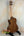 Wooden Kala KA-SCAC-T-CE Tenor Ukulele resting on a black stand for display