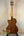 Wooden Kala KA-SCAC-T-CE Tenor Ukulele with natural finish on black stand