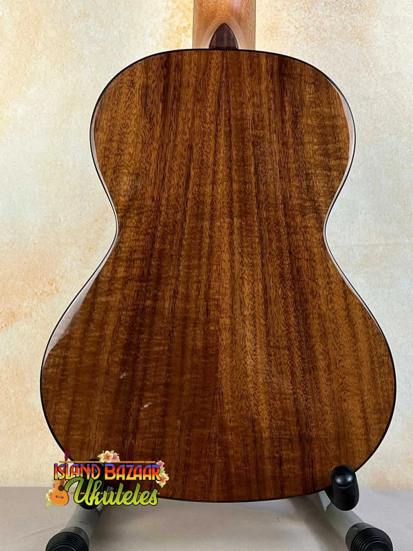 Wooden acoustic guitar with brown grain patterns beside Kala KA-SCAC-T6 6-string tenor ukulele