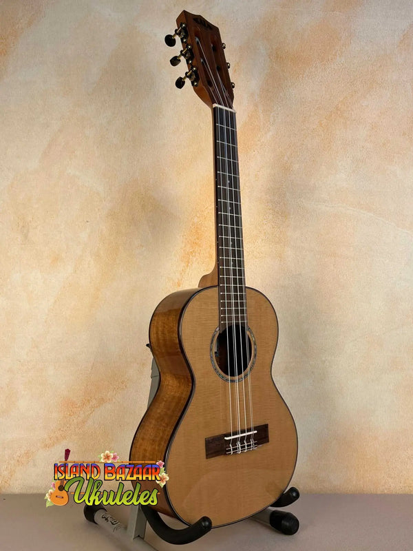 Natural wood Kala KA-SCAC-T6 6-string tenor ukulele on black stand