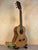 Natural wood Kala KA-SCAC-T6 6-string tenor ukulele on black stand