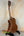Wooden Kala KA-SMH-TG-CE Tenor Electric Ukulele on black stand showcasing solid mahogany