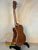 Wooden Kala KA-SMH-TG-CE Tenor Electric Ukulele on black stand showcasing solid mahogany