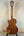 Wooden acoustic guitar on black stand showcasing Kala KA-SMH-TG-CE Tenor Electric Ukulele