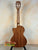 Wooden acoustic guitar on black stand showcasing Kala KA-SMH-TG-CE Tenor Electric Ukulele