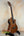 Wooden Kala KA-SMH-TG-CE Tenor Electric Ukulele on a black stand, showcasing solid mahogany