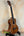 Kala KA-SMH-TG Solid Mahogany Tenor Ukulele with dark grain and white trim on stand