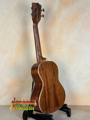 Wooden Kala KA-SMH-TG Solid Mahogany Tenor Ukulele on a sleek black stand