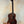 Dark brown wooden Kala KA-SMHT Tenor Ukulele on black stand showcasing classic design