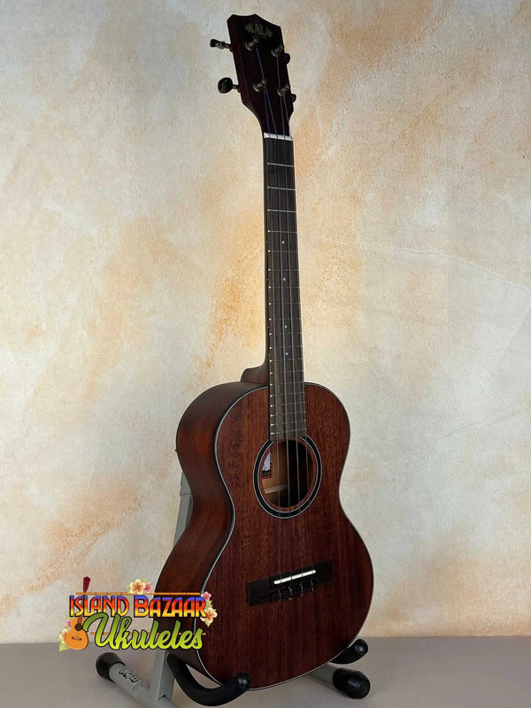 Dark brown wooden Kala KA-SMHT Tenor Ukulele on black stand showcasing classic design