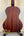 Wooden acoustic guitar on a black stand, paired with Kala KA-SMHT Tenor Ukulele