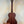 Wooden acoustic guitar with dark mahogany finish next to Kala KA-SMHT Tenor Ukulele