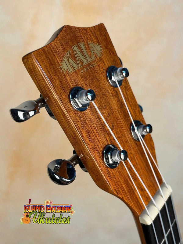 Wooden headstock of Kala KA-STGE-C Tenor Ukulele with tuning pegs and strings