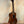 Wooden Kala Left-Handed U-Bass Ukulele in Exotic Mahogany resting on a stand