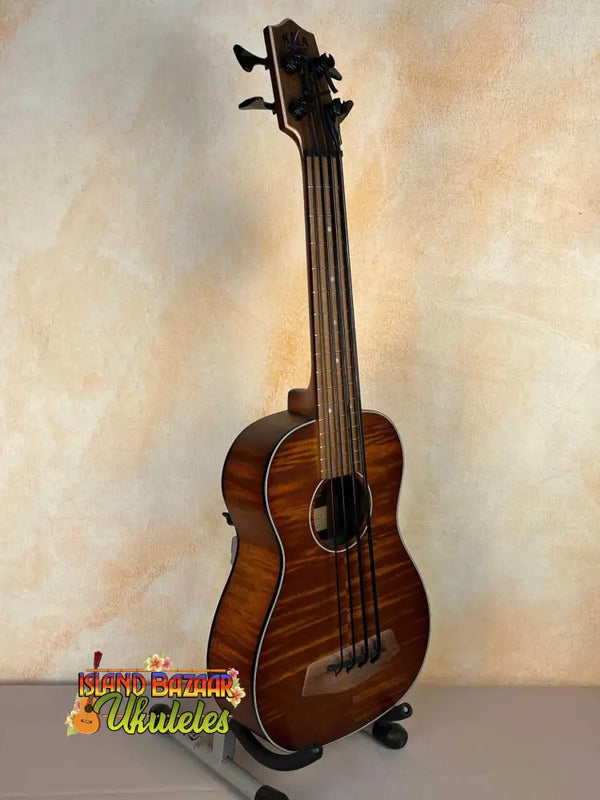 Wooden Kala Left-Handed U-Bass Ukulele in Exotic Mahogany resting on a stand