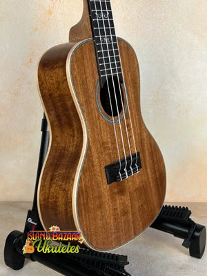 Kala SA-C Concert Ukulele with Spruce & Acacia on a black stand, elegant design