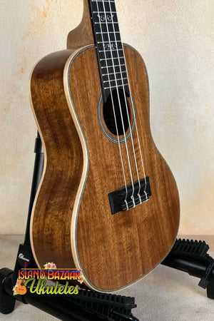 Kala SA-C Concert Ukulele with Spruce & Acacia on a black stand, elegant design