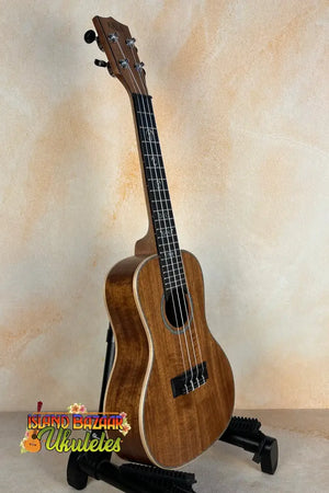 Wooden Kala SA-C Concert Ukulele on a black stand, showcasing Spruce & Acacia design