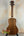 Wooden ukulele with dark grain and black tuning pegs, featuring Kala SA-C Concert design