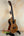 Wooden ukulele with a glossy finish on a stand, featuring the Kala SA-TE-C Tenor Electric