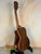 Wooden acoustic guitar with dark brown finish on black stand for Kala SA-TE-C Tenor Electric