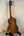 Wooden Kala Satin Hawaiian Koa Tenor Electric Ukulele on a black stand