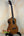 Kala Satin Hawaiian Koa Tenor Electric Ukulele with EQ on a black stand