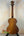 Kala Satin Hawaiian Koa Tenor Electric Ukulele with EQ on black stand, natural finish