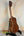 Wooden Kala SMH-CG Concert Ukulele on a black stand showcasing solid mahogany design
